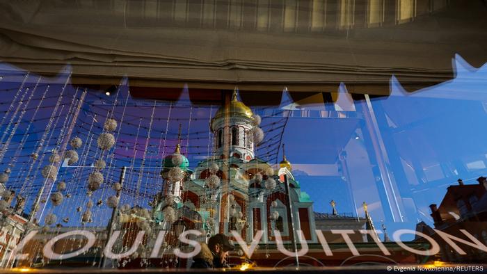 A orthodox church is reflected in the window of a Louis Vuitton store