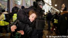 A woman, in a headlock, being pulled away from a demonstration by a policeman in Saint Petersburg, Russia