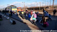 People carry their belongings as they walk to catch a train to Budapest at the station in Zahony, Hungary, Tuesday, March 8, 2022. U.N. officials said Tuesday that the Russian onslaught has forced more than 2 million people to flee Ukraine. (AP Photo/Darko Vojinovic)