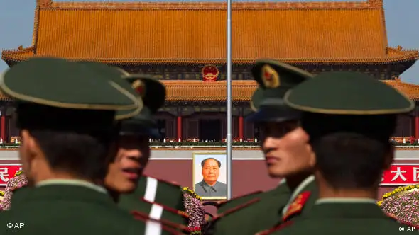 Paramilitary policemen look back while patrolling on the Tiananmen Sqaure in front of the late communist leader Mao Zedong's portrait in Beijing, China, Friday, Oct. 15, 2010. Chinese Communist Party Central Committee meetings open Friday in Beijing, which is expected to approve the economic blueprint for 2011-2015 that will promote policies to close yawning gaps between rich and poor and to encourage consumer spending as a new economic driver. (AP Photo/Alexander F. Yuan)