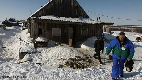 Volkszähler vor einem schneebedeckten Haus im russischen Autonomiegebiet Yamal-Nenets (Foto: AP)