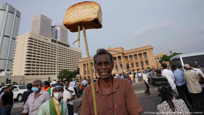 Sri Lankan opposition supporter displays a loaf of bread to highlight the rising food prices