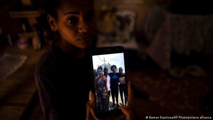 María Carla Milán Ramos muestra una foto en su teléfono móvil de su marido con sus hermanos, todos ellos en prisión acusados de participar en protestas contra el gobierno. (Foto de archivo: 19.01.2022)