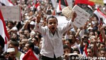 An Egyptian boy holding bread and flashing the victory sign shouts slogans at Cairo's Tahrir Square on April 1, 2011 as he joins tens of thousands of Egyptians who gathered, issuing calls to save the revolution that ousted president Hosni Mubarak and to rid of the country of the old regime. AFP PHOTO/STR (Photo credit should read -/AFP/GettyImages)