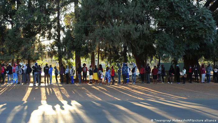 People wait in line to apply for a new passport in Zimbabwe's capital, Harare