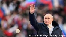 Russian President Vladimir Putin greets the audience as he attends a concert marking the eighth anniversary of Russia's annexation of Crimea at the Luzhniki stadium in Moscow on March 18, 2022. (Photo by Ramil SITDIKOV / POOL / AFP) (Photo by RAMIL SITDIKOV/POOL/AFP via Getty Images)