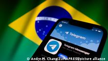 March 18, 2022, Asuncion, Paraguay: Illustration: App icon of Telegram on the App Store, on a smartphone backdropped by displayed cropped waving flag of Brazil. (Credit Image: Â© Andre M. Chang/ZUMA Press Wire