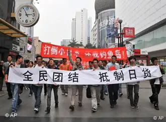 People hold banners while marching during an anti-Japan protest in Chengdu, in southwest China's Sichuan province, Saturday, Oct. 16, 2010. Chinese characters on the banners read, All Chinese Unify To Boycott Japanese Products, and Down With Japan, Return Us Diaoyu Island. Thousands of Chinese have protested against Japan and its claim to disputed islands at demonstrations that were far larger than past protests on the issue.(AP Photo) ** CHINA OUT **