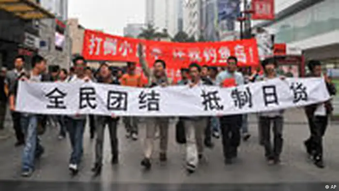 People hold banners while marching during an anti-Japan protest in Chengdu, in southwest China's Sichuan province, Saturday, Oct. 16, 2010. Chinese characters on the banners read, All Chinese Unify To Boycott Japanese Products, and Down With Japan, Return Us Diaoyu Island. Thousands of Chinese have protested against Japan and its claim to disputed islands at demonstrations that were far larger than past protests on the issue.(AP Photo) ** CHINA OUT **