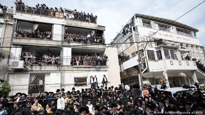People lining streets and balconies in Bnei Brak