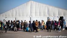 Refugees from Ukraine wait at a newly built arrival center on the tarmac of the former Tegel airport in Berlin, Sunday, March 20, 2022. (AP Photo/Steffi Loos)
