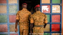 Two soldiers enter the Catholic church at the 10th RCAS army barracks in Kaya, Burkina Faso, Saturday, April 10, 2021. Once considered a beacon of peace and religious coexistence in the region, the West African nation has been embroiled in unprecedented violence linked to al-Qaida and the Islamic State since 2016, throwing an ill-equipped and undertrained army into disarray — and overwhelming the chaplains tasked with supporting them. (AP Photo/Sophie Garcia)