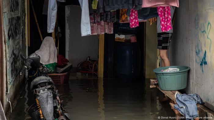 A resident seems to be drying laundry at his house that was submerged by the tidal flood in Muara Angke, Jakarta