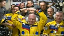 In this photo taken from video footage released by the Roscosmos Space Agency, newly arrived to the ISS, wearing yellow suits, Russian cosmonauts Оleg Аrtemiev, center, Denis Мatveev, right, and Sergei Korsakov pose among other participants of expedition to the International Space Station, ISS, after docking the Soyuz MS-21 spaceship to the station, Friday, March 18, 2022. (Roscosmos Space Agency via AP)