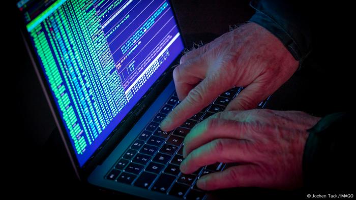 A man typing on a laptop keyboard