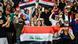 Iraqi football fans hold up flags at a match in 2019 Iraqi football fans hold up flags at a match in 2019