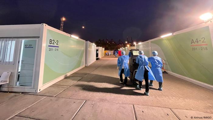 Health personnel distribute food in a quarantine center.