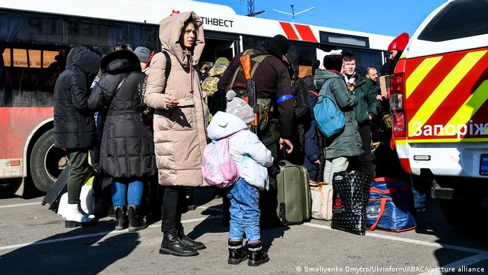Evacuees from Mariupol are seen next to one of 15 buses that carried them toward Berdiansk March 18, 2022