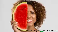 Beautiful African American woman holding a watermelon fruit on her hands || Modellfreigabe vorhanden