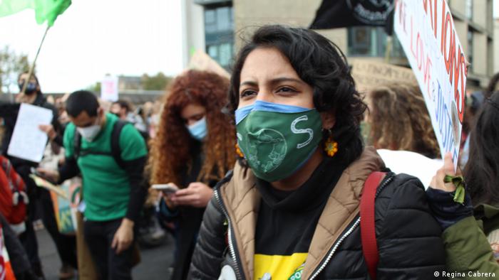 Mexican activist Regina Cabrera protests at a climate strike wearing a green face mask.
