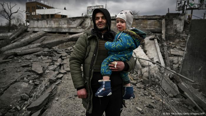 A man holds a child as he flees the city of Irpin, west of Kyiv.