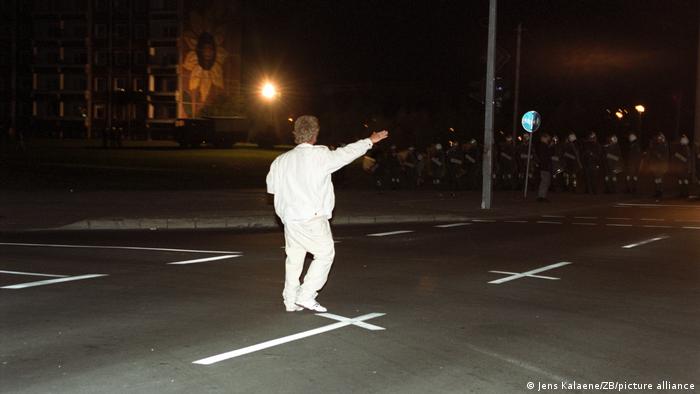 Un joven vestido de blanco muestra el saludo nazi en enfrentamientos con la Policía. 