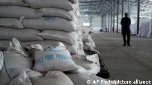 A worker walks past a pile of sacks of food earmarked for the Tigray and Afar regions in a warehouse of the World Food Programme (WFP) in Semera, the regional capital for the Afar region, in Ethiopia Monday, Feb. 21, 2022. (AP Photo)
