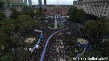 In this aerial view hundreds of people carry a large banner with portraits of people disappeared during the military dictatorship (1976-1983) in the framework of a gathering to commemorate the 46th anniversary of the coup, at Plaza de Mayo Square in Buenos Aires on March 24, 2022. - About 30,000 people went missing after being arrested during the right-wing military regime accused of being leftist sympathizers or deemed subversive, according to Human Rights organizations. (Photo by Elena BOFFETTA / AFP)