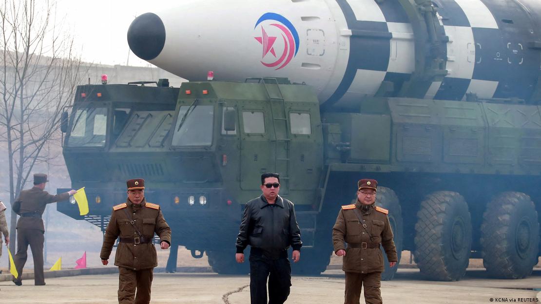 Kim Jong-un em frente míssil transportado por grande veículo militar