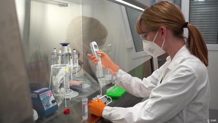 A masked woman working in a lab