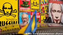 A man walks past a wall with posters depicting Russian President Vladimir Putin, in Warsaw, Poland, on Thursday, March 24, 2022. Ukraine President Volodymr Zelenskyy called on people worldwide to gather in public Thursday to show support for his embattled country as he prepared to address U.S. President Joe Biden and other NATO leaders gathered in Brussels on the one-month anniversary of the Russian invasion. (AP Photo/Petr David Josek)