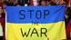 Foto de una persona que sostiene una bandera de Ucrania con las palabras "Detengan la guerra". Foto de una persona que sostiene una bandera de Ucrania con las palabras "Detengan la guerra".