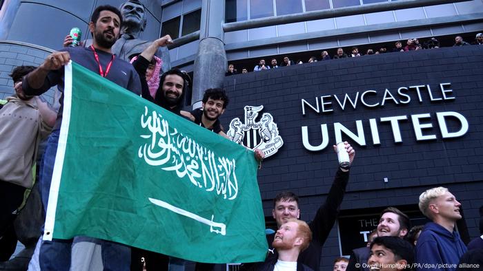 Fans von Newcastle United halten vor dem Stadion eine saudische Flagge hoch