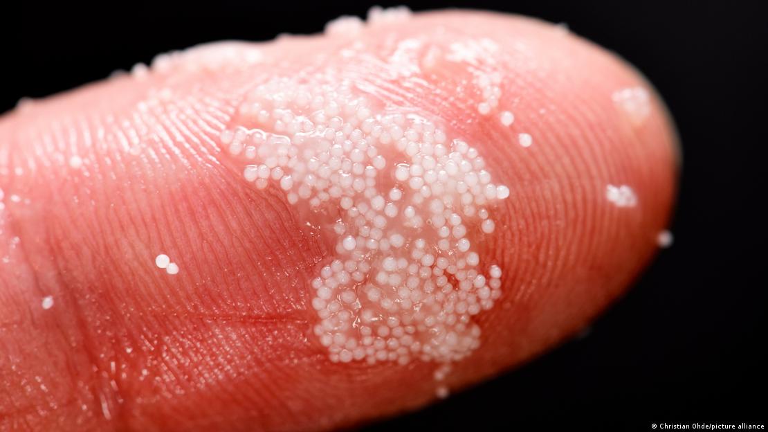 Partículas microplásticas en un dedo.