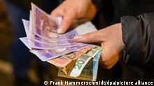 Eine Frau hält ukrainische Geldscheine in die Kamera. Politiker mehrerer Parteien haben eine schnelle Lösung für den Umgang mit der ukrainischen Währung gefordert. Viele Geflüchtete hätten Schwierigkeiten, die Landeswährung Hrywnja in Deutschland umzutauschen. +++ dpa-Bildfunk +++