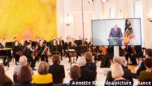 Die Berliner Philharmoniker sitzen im Schloss Bellevue vor ein paar Dutzend Zuschauern während Bundespräsident Frank-Walter Steinmeier wegen Krankheit per Video zugeschaltet ist. Er spricht vor dem Konzert «Für Freiheit und Frieden. Ein Konzert der Berliner Philharmoniker im Schloss Bellevue».