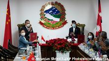 Nepalese foreign minister Narayan Khadka, standing right, and Chinese Foreign Minister Wang Yi applaud during an exchange of agreement in Kathmandu, Nepal, Saturday, March 26, 2022.