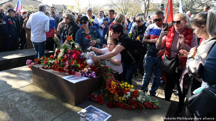 Pro-Russia sympathizers lay flowers at a memorial for Soviet soldiers who died in World War Two