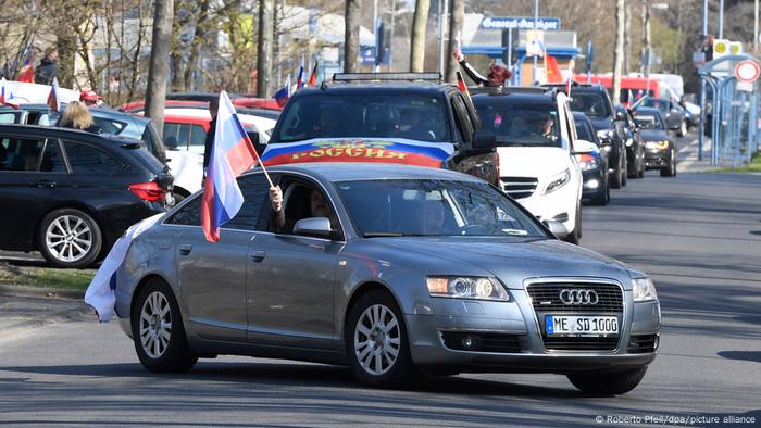 Cars adorned with Russian flags drive through Bonn