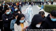 People line up near a makeshift nucleic acid testing site outside a shopping mall during a mass testing for the coronavirus disease (COVID-19), in Beijing, China March 21, 2022. REUTERS/Carlos Garcia Rawlins