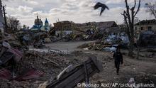 A journalist walks amid the destruction after a Russian attack in Byshiv on the outskirts of Kyiv, Ukraine, Sunday, March 27, 2022. (AP Photo/Rodrigo Abd)