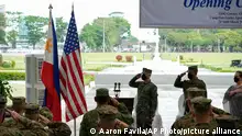 Philippine and U.S. soldiers salute to their flags as the national anthem is played during opening ceremonies of the Balikatan or Shoulder to Shoulder joint military exercises at Camp Aguinaldo, Quezon City, Philippines on Monday, March 28, 2022. Thousands of American and Filipino forces opened on Monday one of their largest combat exercises in years that will include live-fire training, urban assaults, amphibious landing and coastal defense in the northern Philippine region near its sea border with Taiwan. (AP Photo/Aaron Favila)