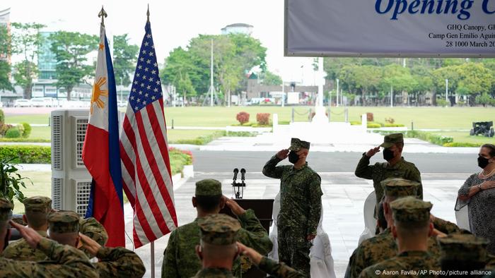 Philippine and US soldiers salute their flags as the national anthem is played during opening ceremonies of the Balikatan 