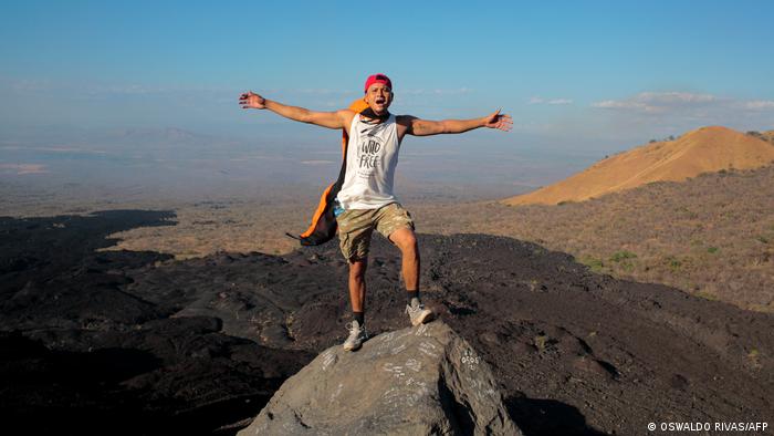 Lester Centeno, a local guide, poses atop Cerro Negro, arms outstreched