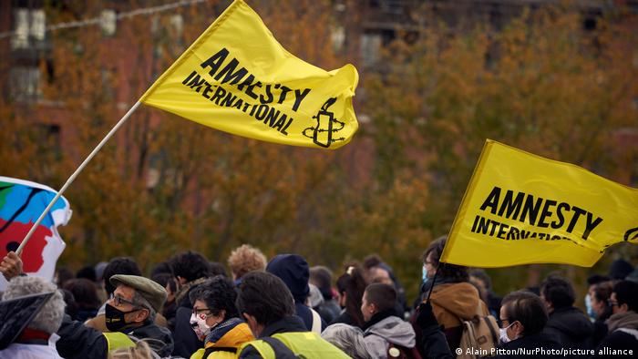 Two flags of the NGO Amnesty International above protesters' heads in Toulouse, France