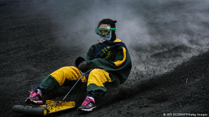 A woman in protective kit speeds down the volcano 