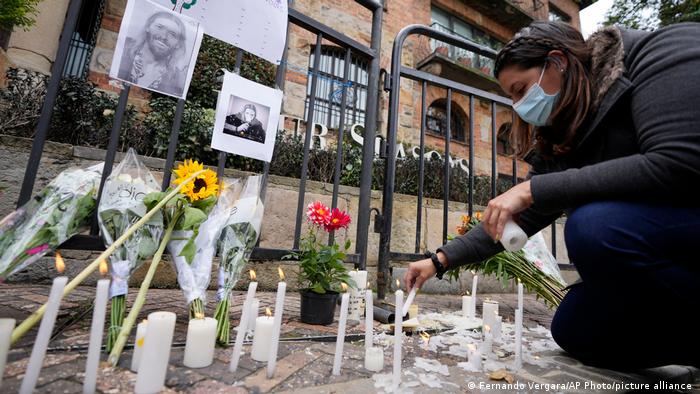 Un fanático enciende una vela en un monumento improvisado para el baterista de Foo Fighters, Taylor Hawkins, en la puerta de un hotel donde Hawkins fue encontrado muerto, en el norte de Bogotá, Colombia.