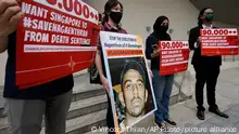 FILE - Activists hold placards and a picture of Nagaenthran K. Dharmalingam before they sent memorandum against the impending his execution, outside the Singaporean embassy in Kuala Lumpur, Malaysia on Nov. 23, 2021. Singapore’s top court has postponed an appeal hearing challenging the death sentence of Nagaenthran who is believed to be mentally disabled, his lawyer said Tuesday, Nov. 30, 2021. Nagaenthran K. Dharmalingam was to be executed by hanging for trying to smuggle less than 43 grams (1.5 ounces) of heroin into the country. (AP Photo/Vincent Thian, File)