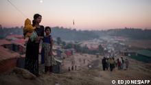 TOPSHOT - Rohingya migrants stand along a track running through the Thankhali refugee camp in Cox's Bazar on December 2, 2017. - Rohingya are still fleeing into Bangladesh even after an agreement was signed with Myanmar to repatriate hundreds of thousands of the Muslim minority displaced along the border, officials said on November 27. (Photo by Ed JONES / AFP) (Photo by ED JONES/AFP via Getty Images)