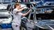 Una mujer trabaja en un coche en una línea de montaje
